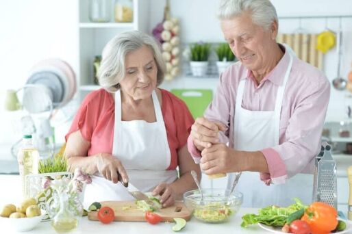 Senior couple cooking a meal together to celebrate National Nutrition Month.
